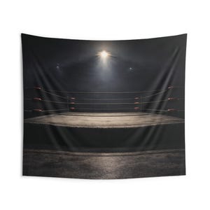 May include: A dark, dramatic tapestry featuring a wrestling ring. The ring is centered, with ropes and corner posts visible. A bright spotlight shines down, creating a smoky atmosphere. The overall color scheme is dark with a focus on the ring.