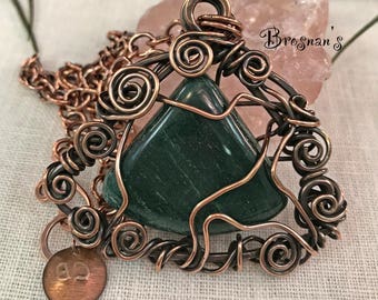 May include: A copper wire wrapped pendant featuring a green gemstone. The pendant is attached to a copper chain with a small copper tag that says "93".