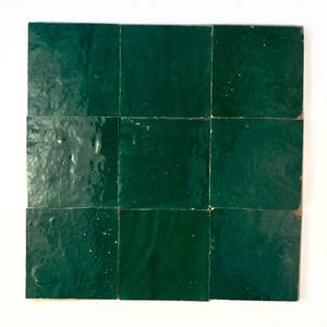May include: A grid of nine square tiles arranged in a three-by-three pattern. Each tile features a deep, glossy forest green glaze with a slightly uneven, textured surface that reflects light, creating subtle variations in the dark green color.