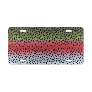 May include: Rectangular license plate featuring a colorful pattern inspired by a rainbow trout. The design includes a gradient of colors, with green, red, and blue hues, and is speckled with black dots. The plate has four mounting holes.