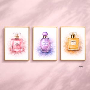 Może przedstawiać: Trzy oprawione wydruki artystyczne przedstawiające ilustracje flakonów perfum. Butelki są w kolorze różowym, fioletowym i żółtym, każda ze złotą nakrętką i napisem "LUXURY IS AN ATTITUDE". Tła mają plamy koloru w stylu akwareli.