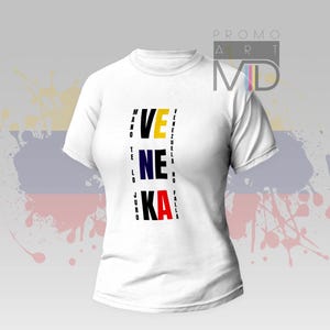 Könnte beinhalten: Weißes T-Shirt mit dem Wort "VENEZUELA" vertikal in Schwarz, Gelb, Blau und Rot ausgerichtet. Das Shirt hat einen Rundhalsausschnitt und kurze Ärmel. Das Design enthält zusätzlichen Text auf beiden Seiten.