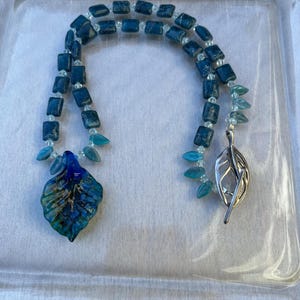 Necklace made with Blue Apatite stones, clear crystals, small glass leaves, a Glass pendent and silver leaf clasp. 17 1/2&quot;
