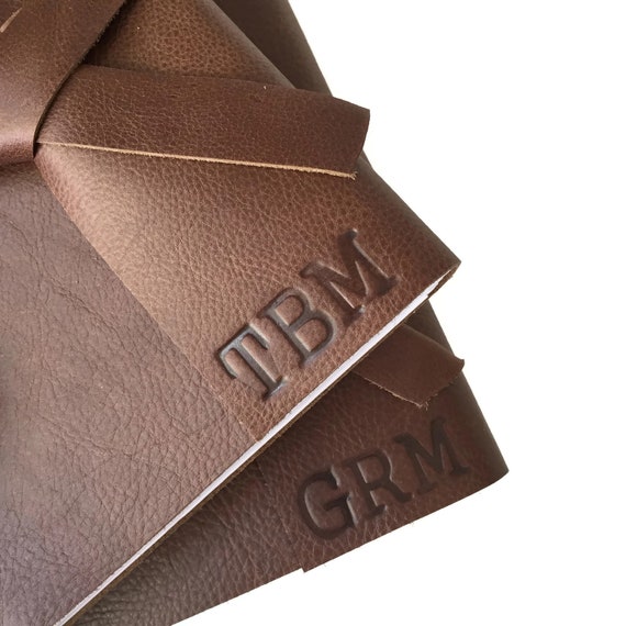 Hand-stitched genuine leather sketchbook with monogram — the kind of object that makes an artist feel like a serious professional the moment they hold it.