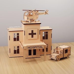 Peut inclure: Maquette en bois d'un hôpital avec un hélicoptère sur le toit et une ambulance. L'hôpital porte une croix et le mot "HOSPITAL" sur le devant. L'hélicoptère porte le mot "AMBULANCE".