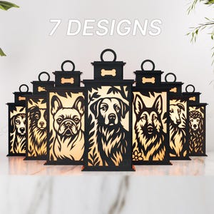 Puede incluir: Linternas decorativas negras con diseños de perros, incluyendo un Bulldog Francés y un Pastor Alemán. Cada linterna tiene un asa y un detalle en forma de hueso. El texto "7 DESIGNS" se muestra encima de las linternas.
