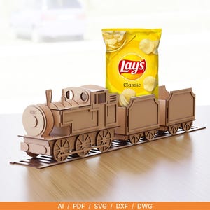 Könnte beinhalten: Ein hölzerner Chiphalter in Form einer Lokomotive mit einer Tüte Lay's Classic Kartoffelchips. Die Lokomotive ist aus hellbraunem Holz gefertigt und hat ein detailliertes Design. Die Lay's-Tüte ist gelb mit dem Markenlogo und dem Wort "Classic".