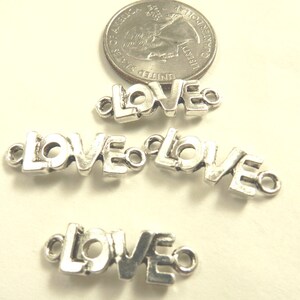 May include: Four silver-toned metal charms in the shape of the word "LOVE". Each charm has two small loops for attaching to a necklace, bracelet, or other jewelry.