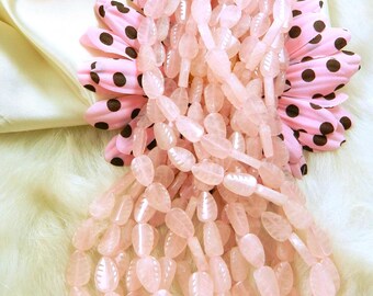 May include: A strand of pale pink, leaf-shaped gemstone beads. The beads are strung on a thin cord and are arranged in a loose, flowing pattern.