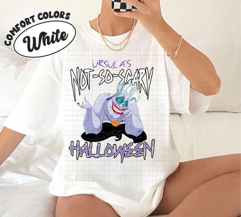 May include: White t-shirt with the text "URSULA'S NOT-SO-SCARY HALLOWEEN" and a cartoon illustration of Ursula from The Little Mermaid. The shirt also has the words "COMFORT COLORS" and "White" in a circle.
