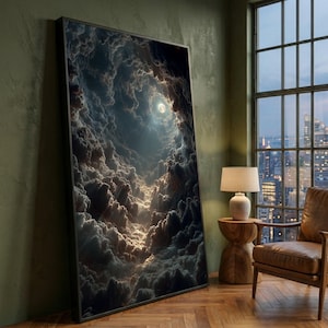 Könnte beinhalten: Ein gerahmter Kunstdruck zeigt eine Himmelslandschaft mit einem Vollmond, der durch einen Wolkentunnel scheint. Das Kunstwerk weist Grautöne, Weiß und Gold auf und erzeugt eine dramatische und ätherische Atmosphäre. Der Druck wird in einem Raum mit Fenster und Möbeln ausgestellt.