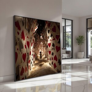 May include: Framed art print depicting a tunnel of playing cards with a child walking towards the light. The cards feature red hearts, black spades, clubs, and diamonds. The artwork is displayed in a modern living space.
