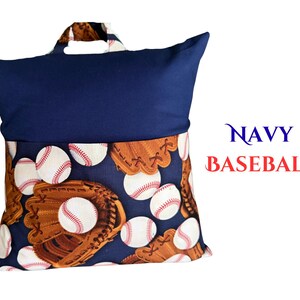 Puede incluir: Coj&iacute;n de lectura azul marino con dise&ntilde;o de b&eacute;isbol. El coj&iacute;n tiene una parte superior azul marino y una parte inferior estampada con pelotas y guantes de b&eacute;isbol. El texto "NAVY BASEBALL" es visible.