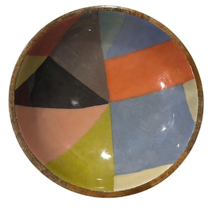 May include: A round wooden bowl with a colorful geometric pattern. The interior features a patchwork design of various shapes in shades of orange, blue, green, pink, and black. The bowl's rim is made of natural wood.