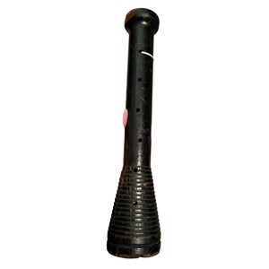 Op de afbeelding: Een zwarte zaklamp in vintage-stijl met een getextureerde, kegelvormige basis en een cilindrisch lichaam. Het heeft een roze accent en verschillende kleine gaatjes. De bovenkant is afgerond.