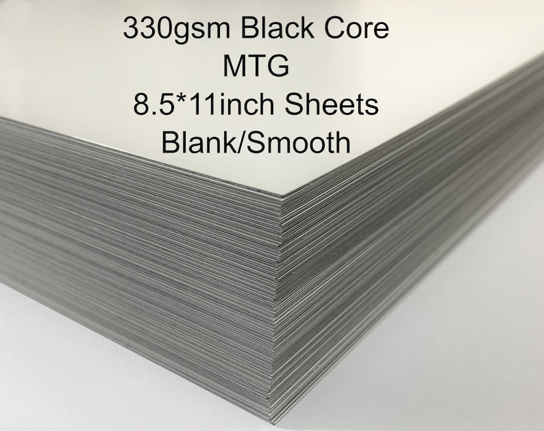 May include: A pile of blank white A4 sheets with a black core. The text on the top sheet reads "330gsm Black Core MTG 8.5*11inch Sheets Blank/Smooth."