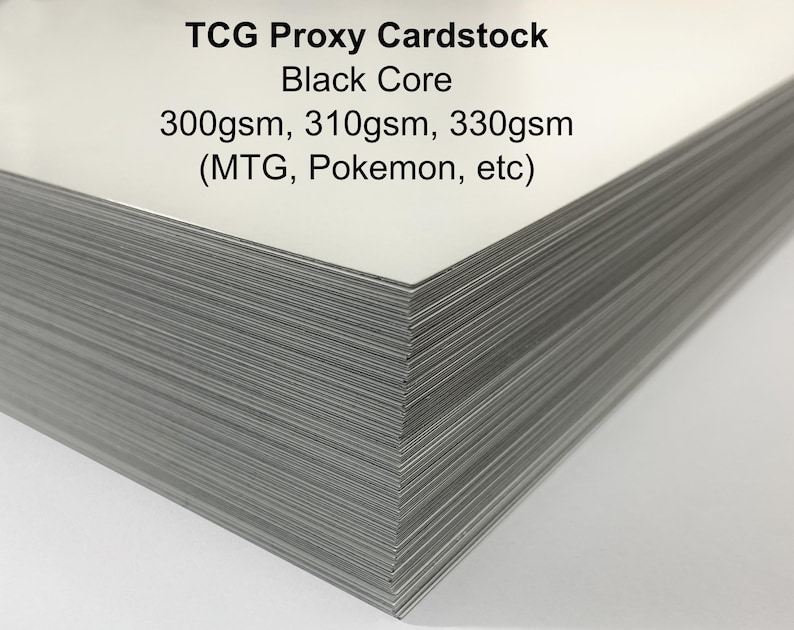 May include: A stack of TCG Proxy Cardstock with a black core. The cardstock is labeled with the text "TCG Proxy Cardstock Black Core 300gsm, 310gsm, 330gsm (MTG, Pokemon, etc)". The cards have a white surface and gray edges.