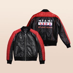 May include: Black leather jacket with red quilted shoulder and back panel accents. The jacket features a zip-up front, two side pockets, and the text "MIAMI VICE STUNT TEAM" on the back.