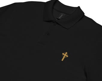 Op de afbeelding: Zwarte poloshirt met een gouden kruis embleem op de linkerborst. De shirt heeft een kraag en drie knopen. Het Gildan-merklabel is zichtbaar op de achterkant van de kraag.