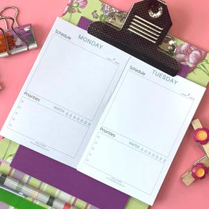 May include: A white notepad with a black clip, featuring sections for 'Schedule', 'Priorities', and 'Water' with water drop icons. The notepad is open to show Monday and Tuesday pages, with a floral patterned background and pink surface.