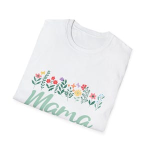 May include: White t-shirt featuring a floral design and the word "Mama" in a light green script. The floral arrangement includes various colourful flowers and green leaves.