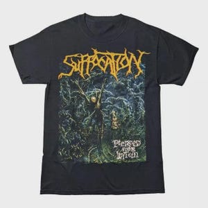 Könnte beinhalten: Schwarzes T-Shirt mit dem Bandnamen "Suffocation" in Gelb, über einer detaillierten Grafik. Die Grafik zeigt eine Figur mit ausgestreckten Armen in einer dunklen, waldartigen Umgebung. Der Text "Pierced From Within" befindet sich darunter.