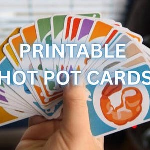 Könnte beinhalten: Eine Hand hält einen Fächer aus bunten Karten mit dem Text "PRINTABLE HOT POT CARDS". Jede Karte hat eine andere Farbe und eine Garnele-Grafik. Das Palia-Logo befindet sich in der oberen linken Ecke.