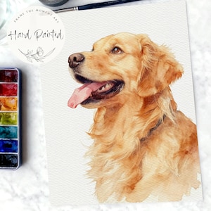 Op de afbeelding: Waterverfschilderij van een Golden Retriever-hond met een lichtbruine vacht en roze tong. Het kunstwerk is handgeschilderd en bevat de tekst "Frame the Moment Art" en "Hand Painted" in een cirkelvormig ontwerp.