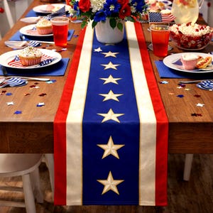 May include: A festive table setting with a patriotic theme. A blue table runner with white stars and red stripes runs down the center of a wooden table. The table is set with plates, napkins, and cupcakes, and decorated with flowers and confetti.