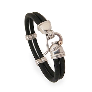 K&ouml;nnte beinhalten: Ein schwarzes Lederarmband mit einem silbernen Verschluss und einem goldenen Akzent. Das Armband ist doppelschichtig und hat einen Hakenverschluss.