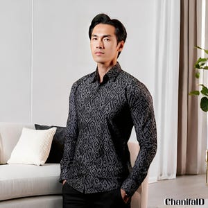 May include: A black and grey patterned long-sleeved shirt with a button-down collar. The shirt is paired with black trousers. The image features the text "ChanifalD" in the bottom right corner.