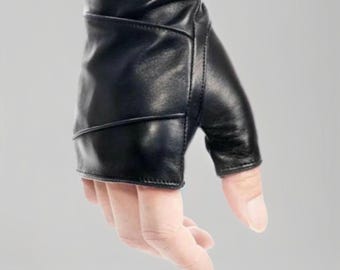 May include: A black leather fingerless glove. The glove is made of smooth, supple leather and features a design with stitched accents. The glove covers the palm and wrist, leaving the fingers exposed. The glove is shown on a hand against a gray background.