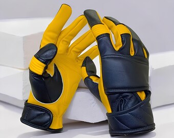 May include: A pair of yellow and black leather gloves. The gloves have a yellow palm and fingers, with black accents on the knuckles, wrist strap, and thumb. The wrist strap has a velcro closure. The gloves are designed for protection and grip.