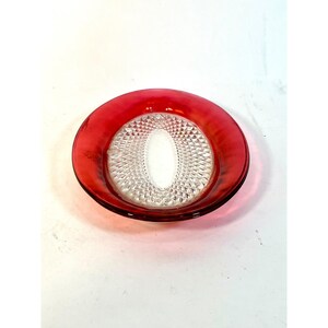 May include: A round glass dish featuring a vibrant red translucent rim and a clear, textured centre with a diamond-patterned border surrounding a smooth, oval-shaped clear glass medallion in the middle of the plate's base.