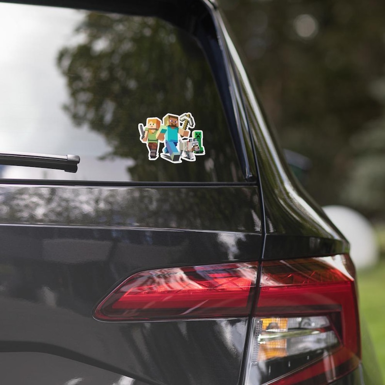 May include: A sticker showing three Minecraft characters: a character with a sword, a character with a pickaxe, and a Creeper. The sticker is on the rear window of a dark-coloured car.