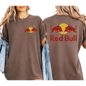 two women wearing brown t-shirts with the Red Bull logo on the back.
