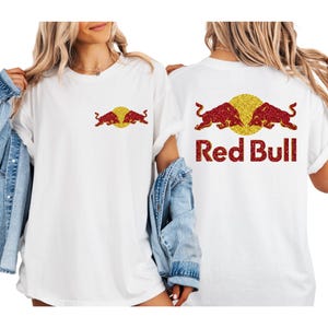 two women wearing white t-shirts with the Red Bull logo and a denim jacket.