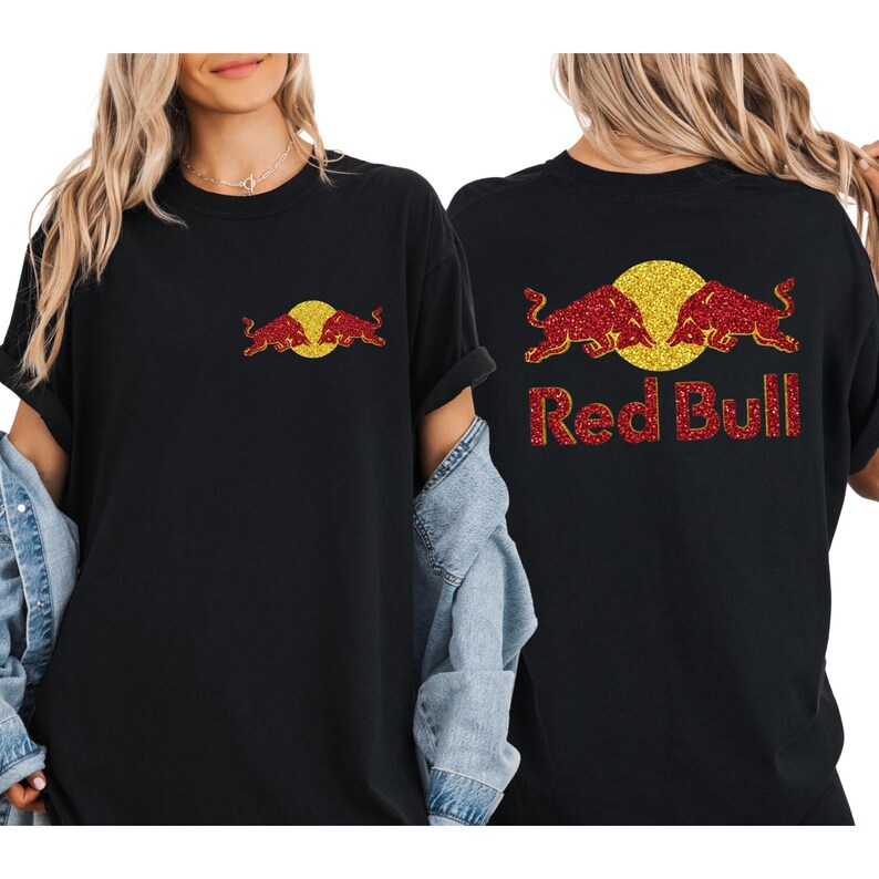 A woman wearing a black t-shirt with a Red Bull logo and a denim jacket.