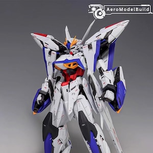 Puede incluir: Modelo detallado de un robot mecha blanco, azul, rojo y negro. El robot tiene un dise&ntilde;o complejo con &aacute;ngulos agudos y alas. El logotipo de AeroModelBuild es visible en la esquina superior derecha.