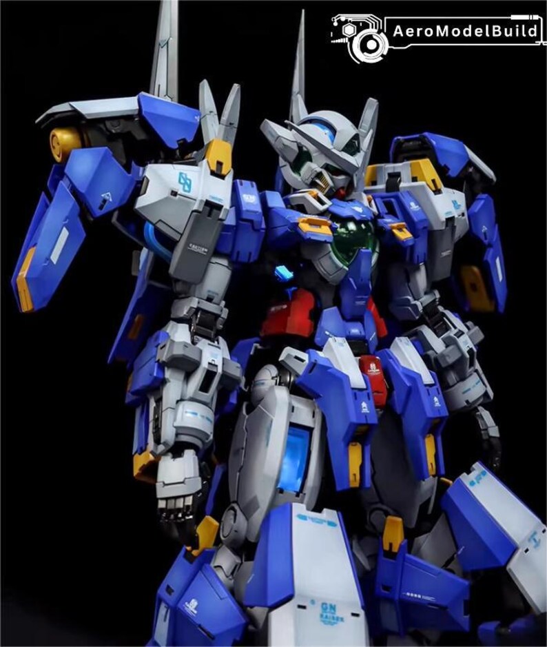 May include: A detailed model of a blue, white, and gray mecha robot with yellow accents. The robot has multiple articulated joints and panels, with a complex design. The image includes the text "AeroModelBuild" in the upper right corner.