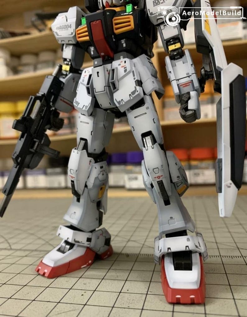 Pode incluir: Modelo detalhado de um rob&ocirc; mecha, principalmente em branco, cinza e vermelho. O rob&ocirc; tem uma arma e um escudo. O modelo &eacute; altamente detalhado com componentes mec&acirc;nicos e linhas de painel vis&iacute;veis. Um item de colecionador.