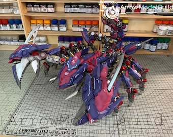 May include: A detailed model of a robotic creature, primarily in shades of purple and red, with silver accents. The model is posed on a cutting mat, with shelves of paint and supplies in the background. The model has multiple articulated parts.