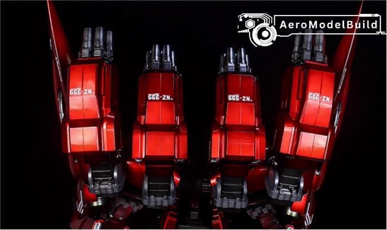May include: Close-up of a red model robot's legs and feet, with the text "666-ZN." visible on each leg. The model has a metallic finish and is set against a black background. The AeroModelBuild logo is in the top right corner.