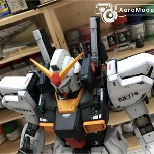 Op de afbeelding: Een gedetailleerde modelbouwkit van een Gundam-robot, met een wit, zwart, oranje en rood kleurenschema. Het model heeft ingewikkelde details, inclusief de tekst "RX-178" en "AeroModelBuild" op de afbeelding.
