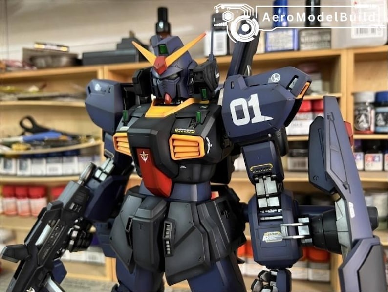 Pu&ograve; includere: Modello dettagliato di un robot Gundam, principalmente blu navy con accenti arancioni, rossi e gialli. Il robot ha un grande scudo, un'arma e il numero "01" sulla spalla. Il testo "AeroModelBuild" &egrave; visibile nell'angolo in alto a destra.