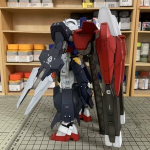 Puede incluir: Modelo detallado de un robot, con una combinaci&oacute;n de colores azul marino, rojo, blanco y gris. El robot tiene un escudo grande y una espada. El modelo est&aacute; colocado sobre una superficie con un patr&oacute;n de cuadr&iacute;cula, lo que sugiere un proyecto de modelismo.