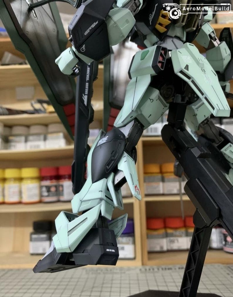 Puede incluir: Maqueta detallada de un robot mecha, con extremidades y paneles articulados. La combinaci&oacute;n de colores incluye tonos verde menta, negro y gris. El modelo est&aacute; montado sobre un soporte, mostrando su pose din&aacute;mica.