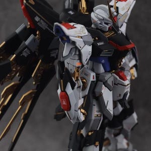 Może przedstawiać: Szczeg&oacute;łowy model robota mecha, gł&oacute;wnie biały, czarny i złoty. Robot ma skomplikowane detale, w tym skrzydła i wiele paneli. Tekst "ArrowModelBuild" jest widoczny w prawym g&oacute;rnym i dolnym środkowym rogu.