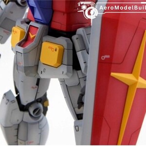 May include: Close-up of a detailed model robot, featuring a red shield with a yellow star design. The robot has gray, yellow, red, and blue components. The text "AeroModelBuild" is visible in the upper right corner.