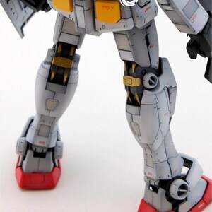 May include: Close-up of a detailed model robot's legs. The model features a color scheme of white, gray, red, and gold. The feet are red, and the joints are gold. The text "AeroModelBuild" is visible in the top right corner.